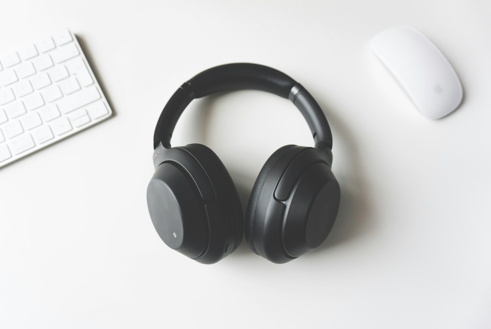 Headphones on a desk beside a keyboard